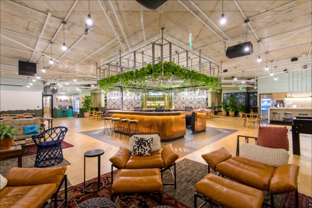 Ambiente corporativo com cobertura em estrutura metálica e bar central